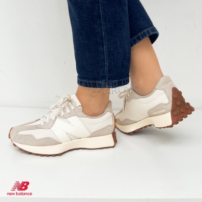 Ténis New Balance bege e branco com sola castanha usados com calças de ganga