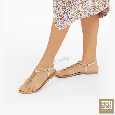 Sandálias rasas bege com correntes douradas em modelo com vestido florido