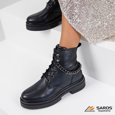 Bota preta de couro com corrente metálica prateada e sola preta grossa.