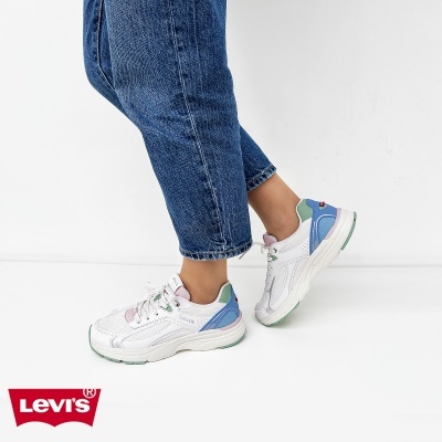 Ténis Levis brancos com detalhes coloridos e calças de ganga azuis