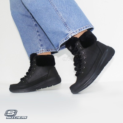Bota preta de inverno com pelúcia, atacadores e sola preta usada com calças de ganga