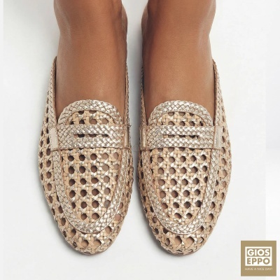 Mocassins de mulher dourados em pele entrelaçada com padrão perfurado.