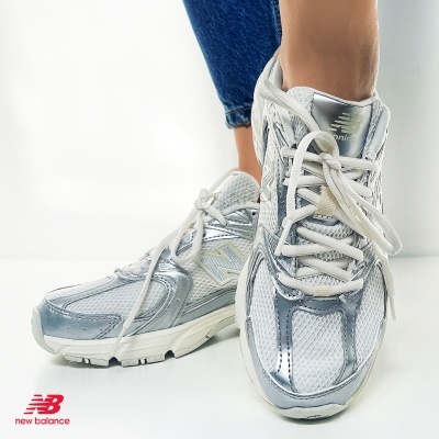 Ténis New Balance branco e prateado com atacadores brancos