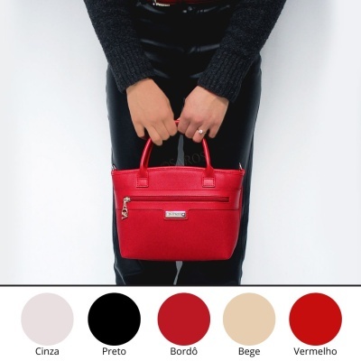 Mala de mão vermelha em pele sintética com fecho metálico, mãos femininas seguram, fundo branco