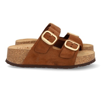 Sandálias de cunha castanhas com fivelas douradas sobre fundo branco