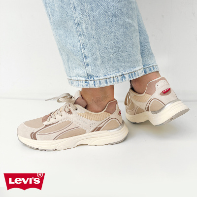 Ténis Levis bege e castanho claro com solado branco e detalhes prateados usados com jeans