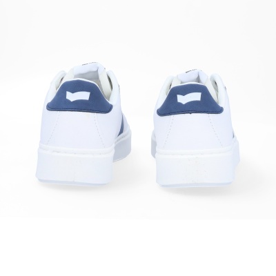 Ténis brancos com detalhes azul-escuro na parte traseira numa superfície branca