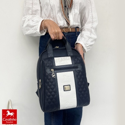 Mochila preta com faixa branca em relevo Cavalinho segurada por pessoa