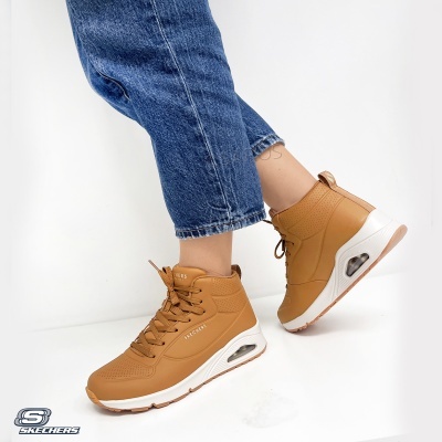 Tênis Skechers castanho claro com sola branca e detalhe visível de amortecimento