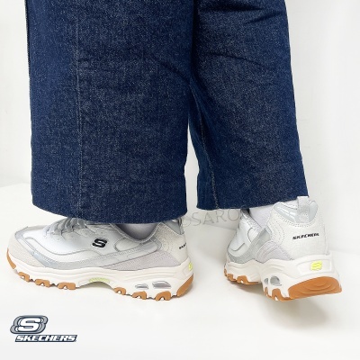 Ténis brancos Skechers com sola castanha e calças de ganga
