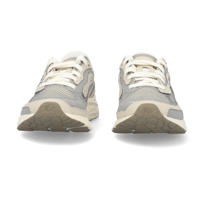 Par de sapatilhas desportivas New Balance cinzento e bege vistas de frente