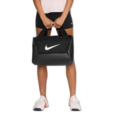 Mulher com bolsa de desporto preta Nike e calções pretos