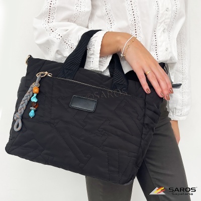 Mala preta acolchoada com chaveiro colorido sendo segurada por uma pessoa