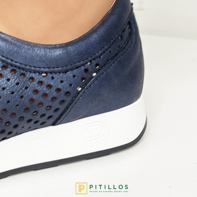 Calçado desportivo azul em pele com perfurações circulares e sola branca com logótipo em relevo