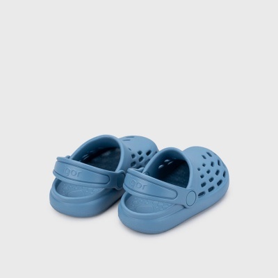 Calçado azul tipo sandália em plástico com furos e tira atrás com o texto igor