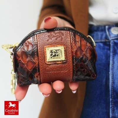Pequena bolsa castanha Cavalinho com textura de pele segurada por mão com unhas pintadas