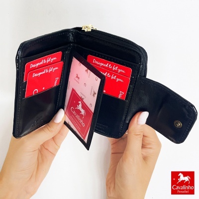 Carteira preta em pele com compartimentos para cartões e moedas com cartões vermelhos da marca Cavalinho