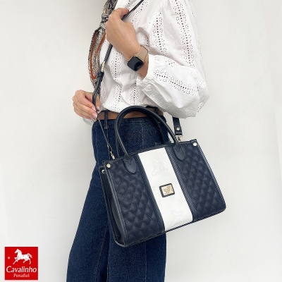 Mala de mão preta e branca com padrão acolchoado e alça longa