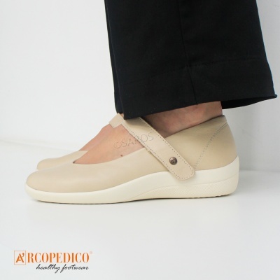 Sapato feminino bege com tira e sola branca ao lado de calças pretas