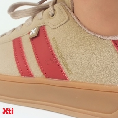 Ténis bege com riscas vermelhas, sola castanha e inscrição dourada na lateral