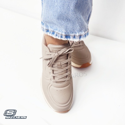 Sapatilhas bege Skechers com cadarços e sola castanha, calças de ganga azul claro