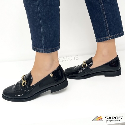 Sapatos mocassim pretos em verniz com detalhe dourado, usados com calças de ganga azul escuro