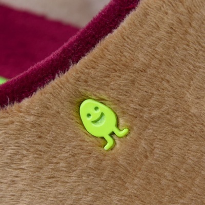 Detalhe de tecido felpudo castanho com aplicação smile verde fosforescente