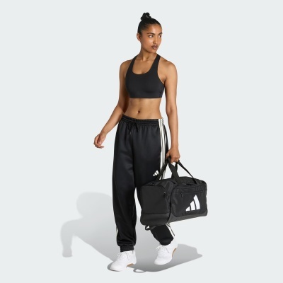 Mulher em roupa desportiva preta a segurar mala de desporto preta com logótipo branco