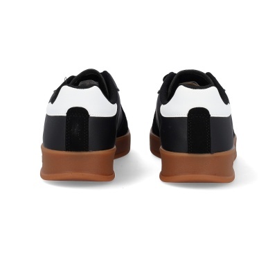 Sapatilhas pretas e brancas com sola castanha vistas de trás