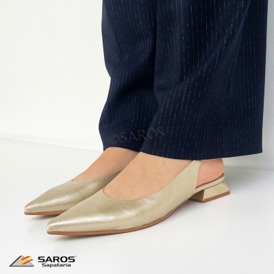 Sapatos dourados com salto baixo usados com calças azul escuro às riscas