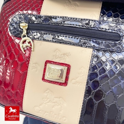 Mala Cavalinho em pele tropicalizada vermelha, azul e bege com textura brilhante e fecho
