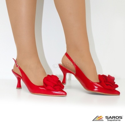 Sapatos vermelhos de salto médio com flor frontal e tira slingback em fundo branco