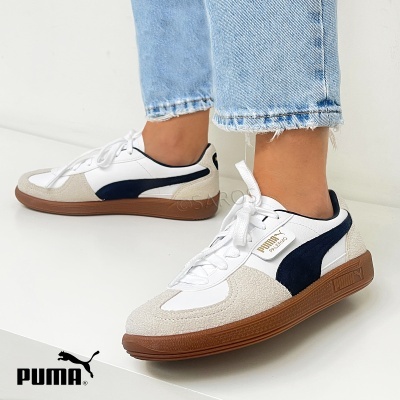 Ténis Puma Palermo branco azul escuro e bege com solado castanho usados com calças de ganga claras