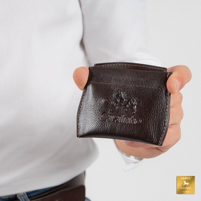 Carteira de pele castanha escura com gravação 'Cavallinho' na mão de uma pessoa com camisa branca.