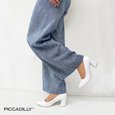 Sapatos brancos de salto médio com calças largas azuis