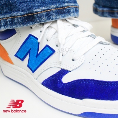 Ténis New Balance branco com detalhes azuis e laranja