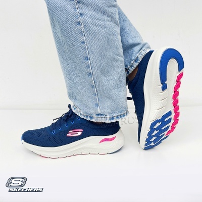 Ténis Skechers azul escuro com sola branca e detalhes rosa usados com jeans claros
