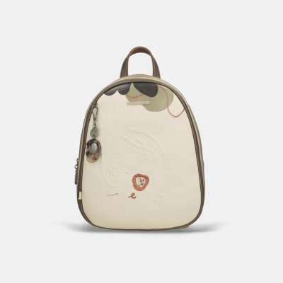 Mochila pequena bege com relevo, chaveiro metálico e padrão colorido no topo.