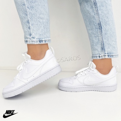 Ténis Nike Air Force 1 brancos usados com jeans azuis claros cortados
