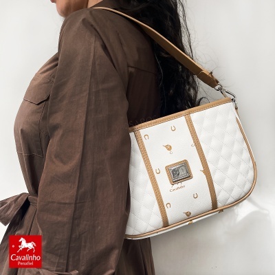 Mala de ombro branca matelassê com detalhes castanhos e estampas douradas, da Cavalinho.