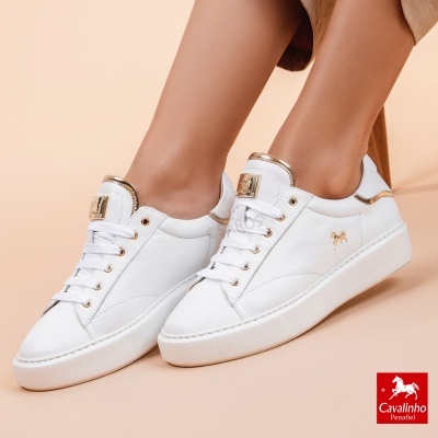 Ténis brancos em pele com detalhes dourados e logo Cavalinho Penafiel