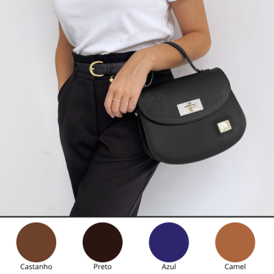 Mala de mão preta em pele com fechos metálicos prateados e alça, em modelo com roupa branca e preta