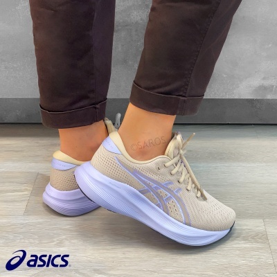 Ténis de corrida castanho claro asics com detalhes lilás e branco, calçados por pessoa em chão claro