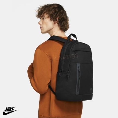 Mochila preta da Nike com alças acolchoadas usada por pessoa com camisola castanha