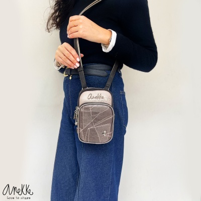 Mala de ombro pequena castanha com assinatura Anekke, usada com blusão preto e jeans azul