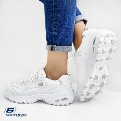 Ténis brancos Skechers com sola robusta e detalhes cinza, usados com jeans azul claro