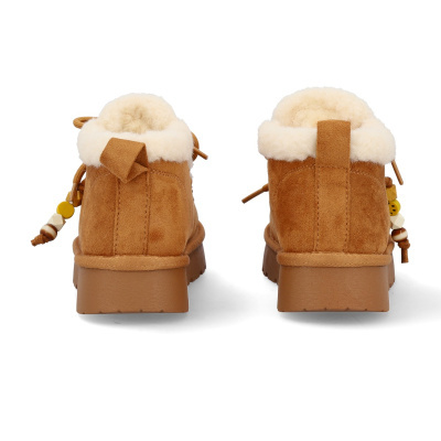 Botins castanhos de camurça com pelo branco e contas coloridas nas laterais vistos de trás
