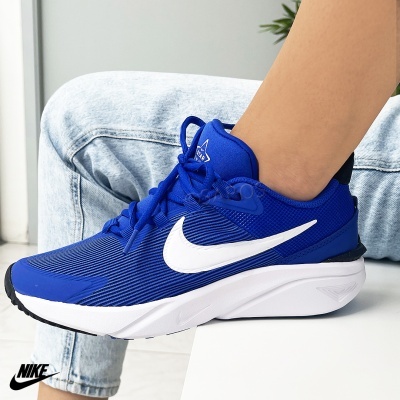 Ténis desportivo Nike azul, branco e preto usados em ambiente interior