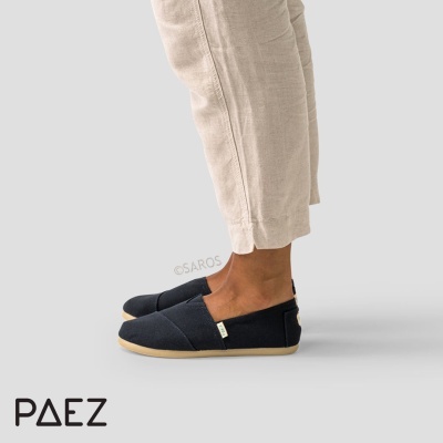 Alpargatas pretas com sola clara usadas com calças de linho bege