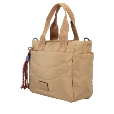 Mala de mão bege acolchoada com alças castanho claro e pendente de franjas azul e vermelho